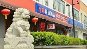 Una estatua de león frente a un edificio con un letrero que dice 