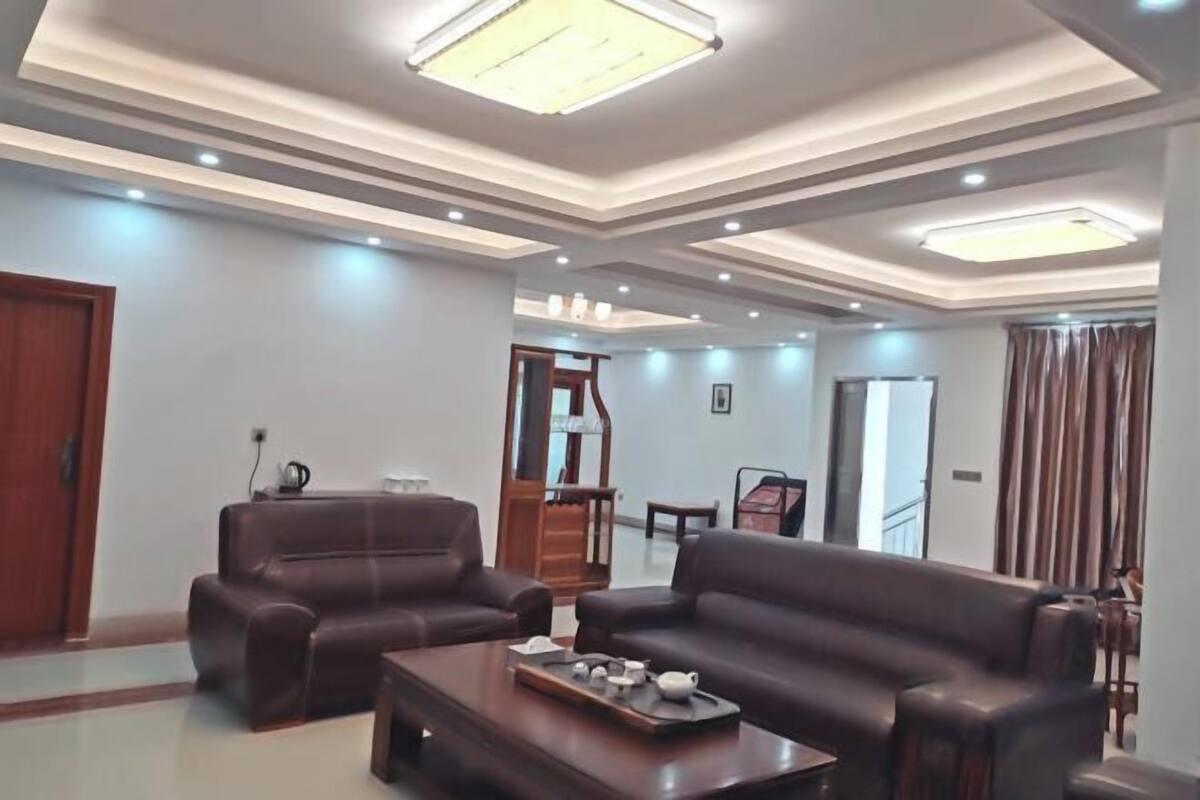 A modern living room with leather sofas, a coffee table, and recessed ceiling lighting.