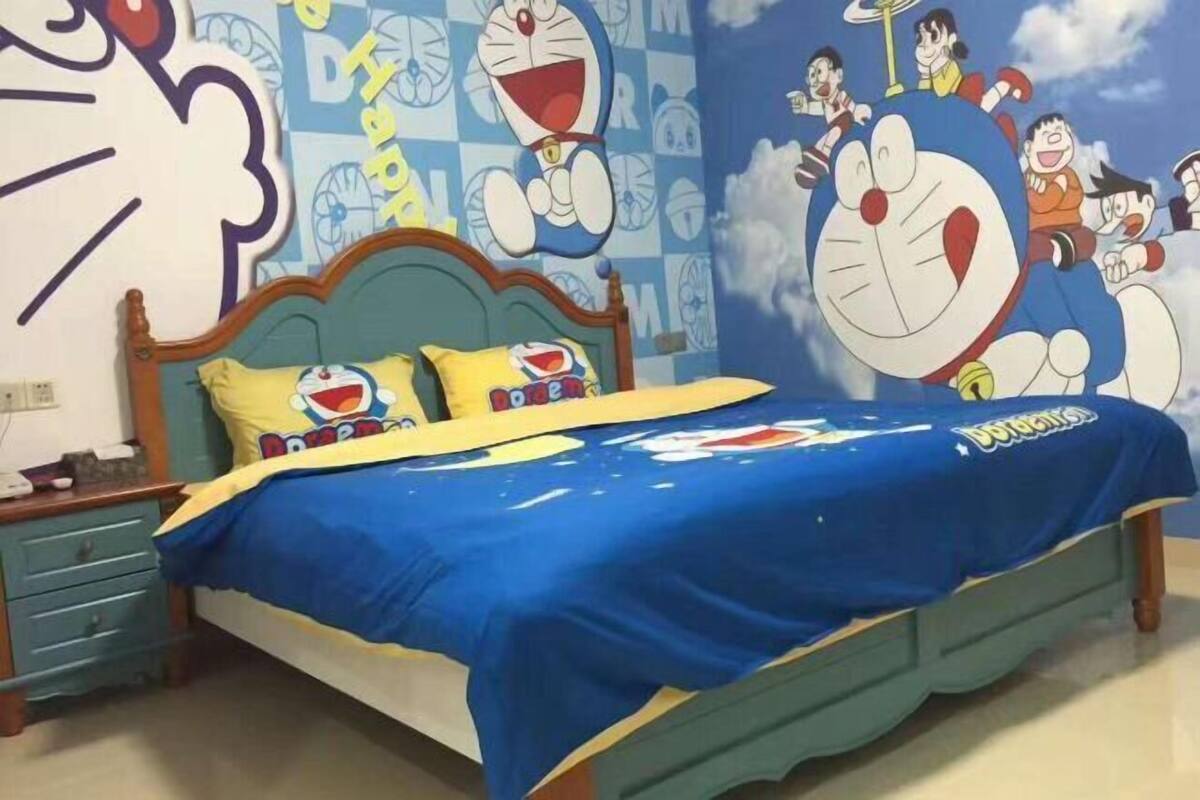 A bedroom with a bed, pillows, and a wall mural.