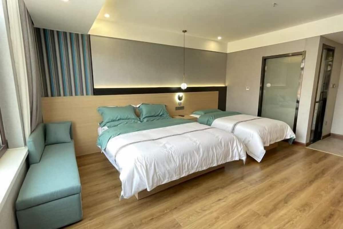 Una habitación de hotel moderna con una cama grande, un sofá y una pequeña mesa.