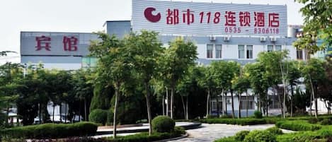 Un edificio con un cartel grande que indica un hotel llamado '118' con números de contacto.