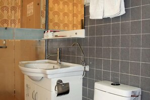 A bathroom with a white sink, a toilet, and a towel rack. - City 118 Zhaoyuan Beicheng (Zhaoyuan)