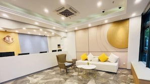 A modern reception area with a reception desk, seating area, and a decorative wall. - EasyGo Motel (Shanghai Dahua Hucheng Branch) (Shanghai)