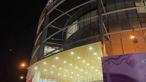 A modern building with a curved facade, illuminated by numerous lights. - EasyGo Motel (Shanghai Dahua Hucheng Branch) (Shanghai)