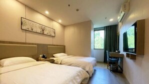 A hotel room with two beds, a desk, a chair, a painting on the wall, and a window with curtains. - EasyGo Motel (Shanghai Dahua Hucheng Branch) (Shanghai)