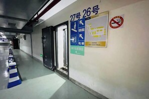A corridor with a door marked 27 and 26, a no-smoking sign, and a poster with a map and contact information. - EasyGo Motel (Shanghai Dahua Hucheng Branch) (Shanghai)