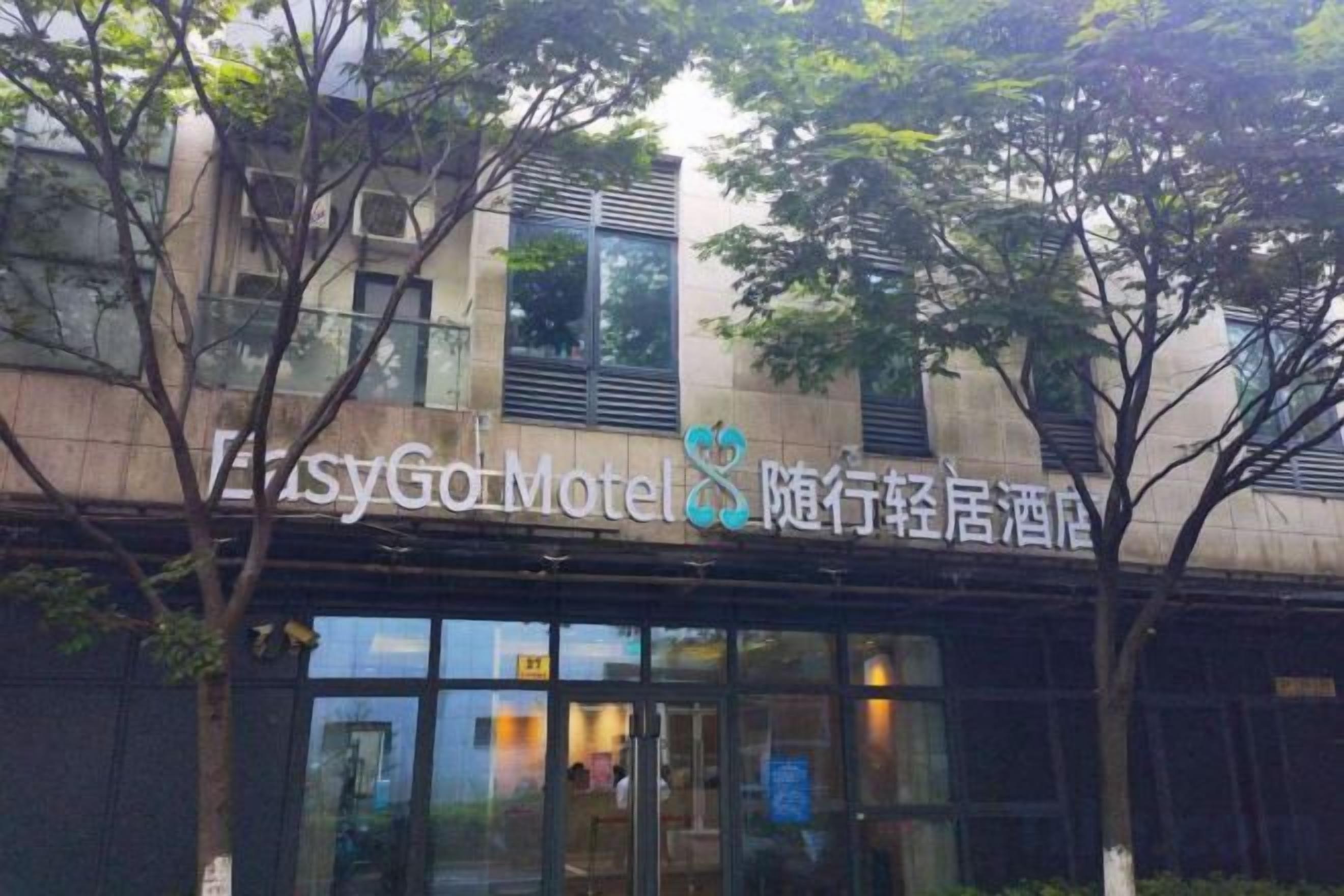 Un edificio con un letrero que dice 'EasyGo Motel' y caracteres chinos.