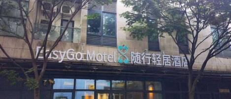 Un edificio con un letrero que dice 'EasyGo Motel' y caracteres chinos.