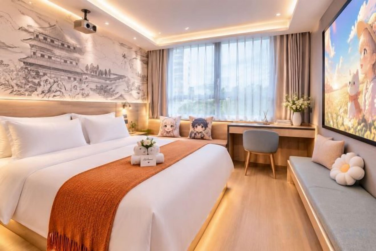 A hotel room with a large bed, a desk, a sofa, and a city view.