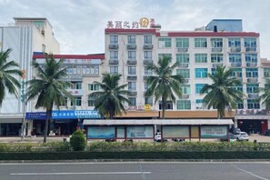 A multi-story hotel with a modern facade, palm trees in front, and various commercial establishments on the ground floor. - Zhuzhou Beauty Zhiyue Hotel (Zhongxing Street Summer Plaza) (Danzhou)