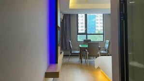 A modern hotel room with a large window, a dining area with a table and chairs, and a built-in desk. - Zhuzhou Beauty Zhiyue Hotel (Zhongxing Street Summer Plaza) (Danzhou)
