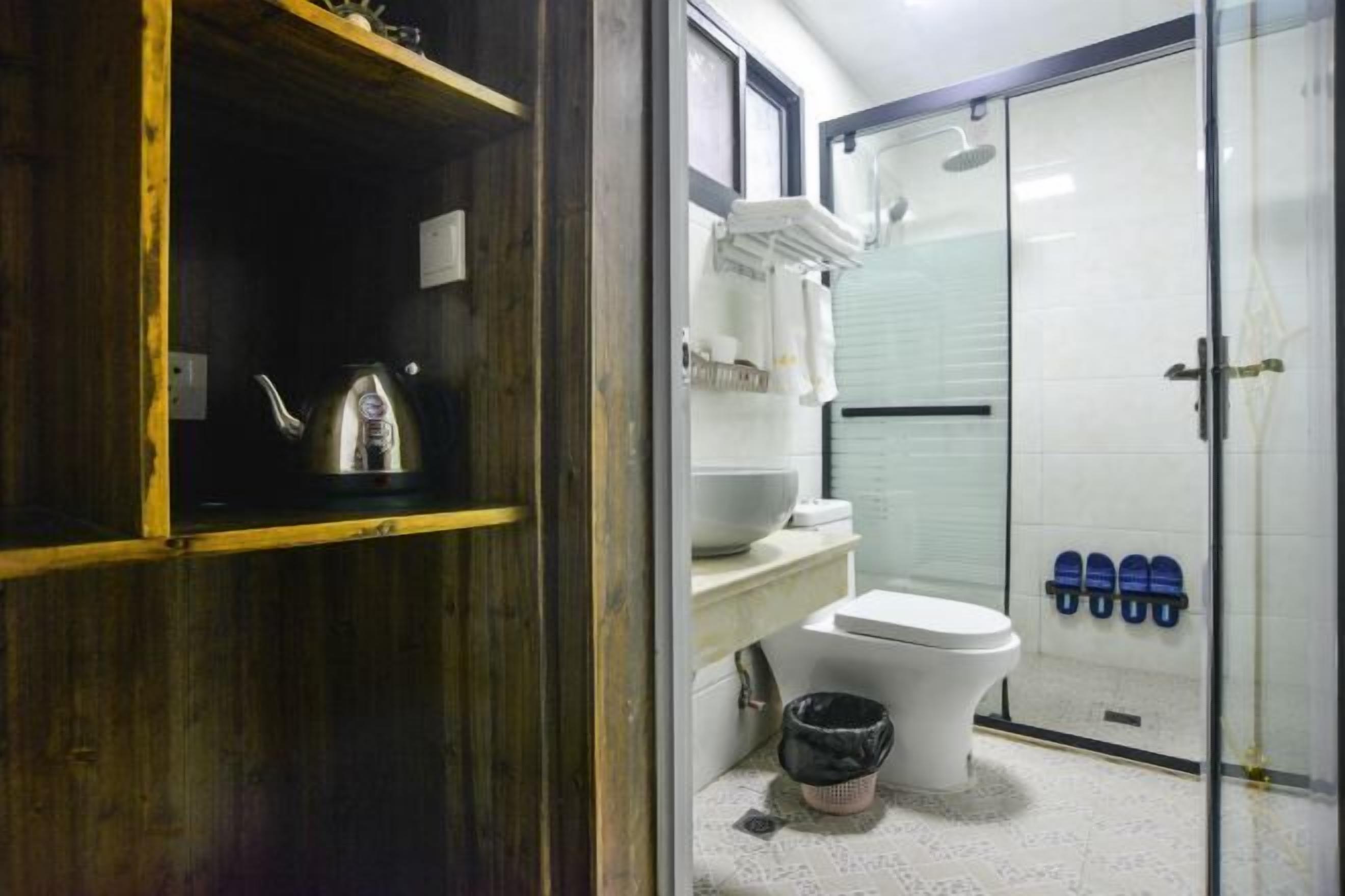 A bathroom with a toilet, a shower, and a sink.