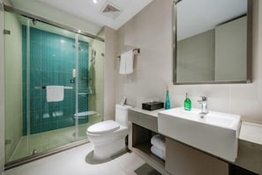 A modern bathroom with a glass shower enclosure, a white toilet, a sink with a mirror, and a towel rack. - Homeinn Business Hotel (Wuhu Fantawild Adventure Development Zone) (Wuhu)