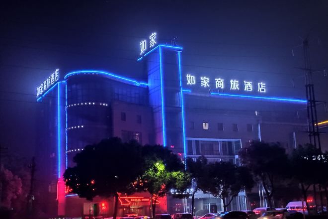 Un hotel con un cartel llamativo y luces de neón azules iluminadas.