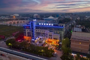 A multi-story hotel with a modern design, featuring a prominent entrance and a parking lot. - Homeinn Business Hotel (Wuhu Fantawild Adventure Development Zone) (Wuhu)