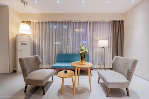 A modern hotel room with a sofa, two armchairs, a small round table, and a lamp. - Homeinn Business Hotel (Wuhu Fantawild Adventure Development Zone) (Wuhu)