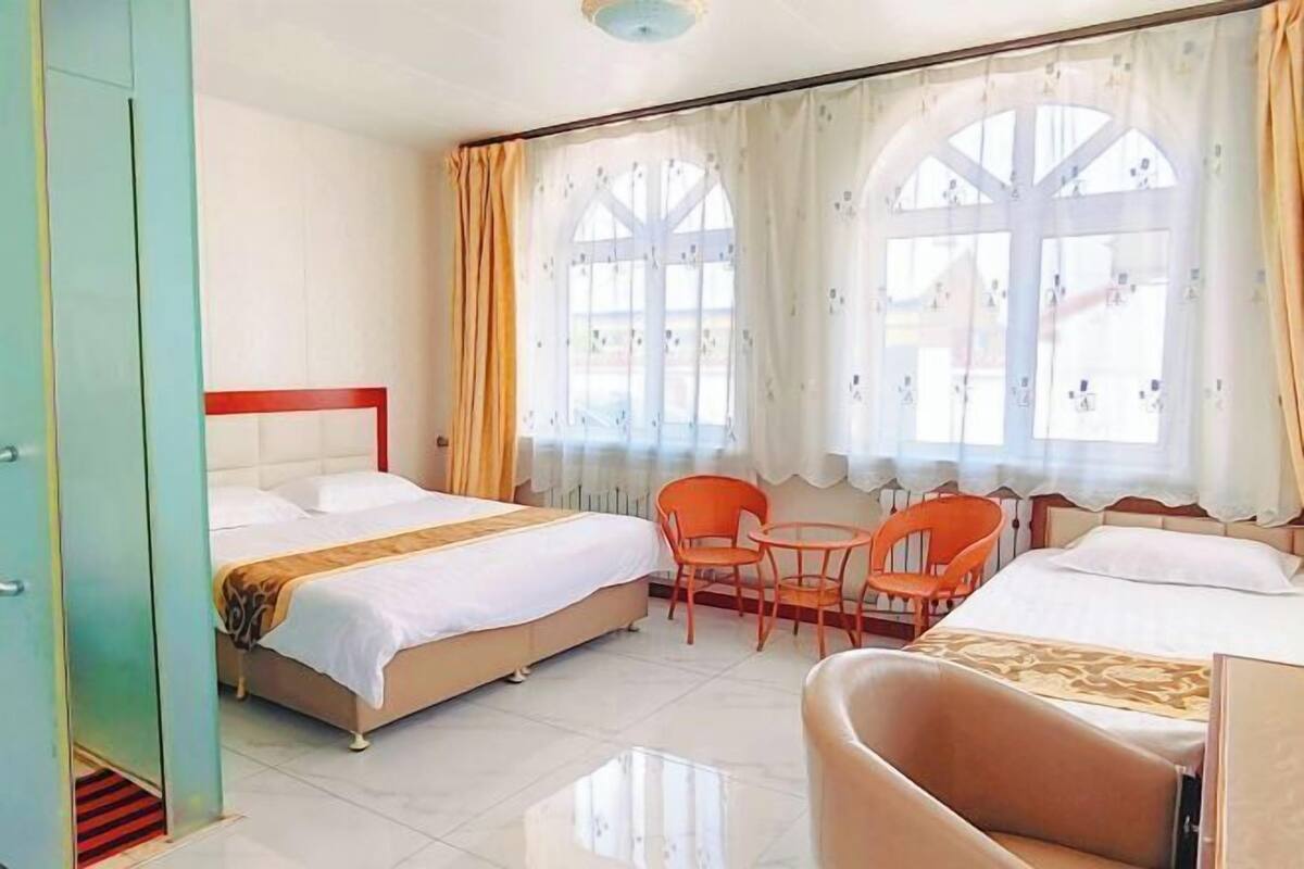Ein Hotelzimmer mit zwei Betten, einem kleinen Tisch und Stühlen.