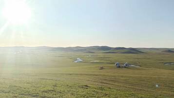 A flat landscape with distant hills and a clear sky.