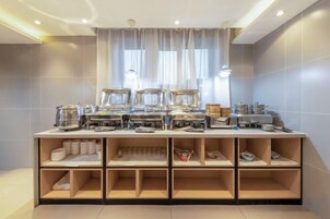 Disposiç ão de buffet com várias estações de serviço, uma janela com cortinas e uma parede revestida com azulejos.
