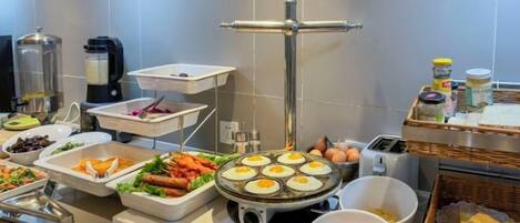 Montaje de bufé con diversos alimentos y una estación de café.