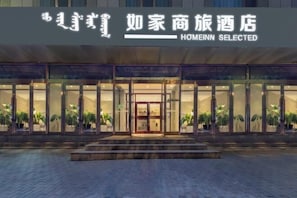 A hotel entrance with glass doors, potted plants, and a sign reading "Homeinn Selected". - Homeinn Selected Hotel (Baotou East Station Airport) (Baotou)
