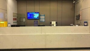 A reception area with a marble counter, a television screen, and informational posters on the wall. - Minjia Hotel(Shanghai Qingpu New City Metro Station Store) (Shanghai)