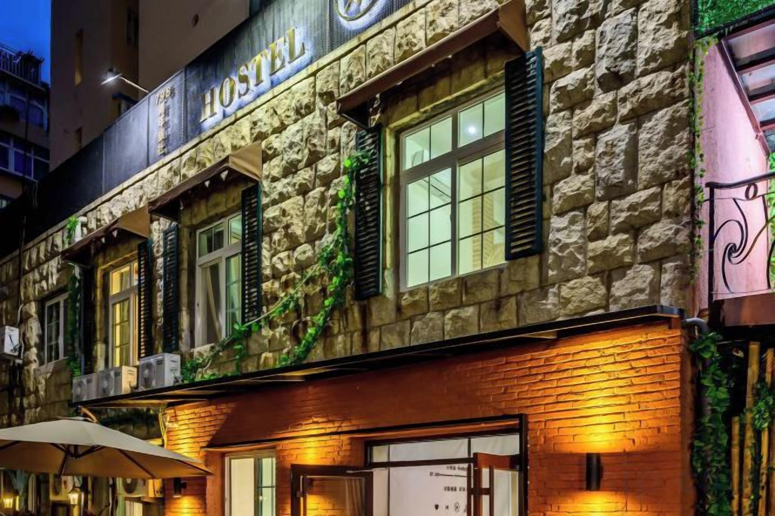 Un edificio de piedra con un letrero que dice 'HOTEL' y una ventana con cortina.