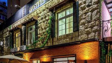 Un edificio de piedra con un letrero que dice 'HOTEL' y una ventana con cortina.