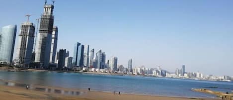 A beach with a city skyline in the background.