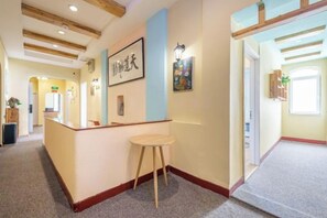 A reception area with a reception desk, a stool, and framed artwork on the wall. - Residential quarters in Yinqi mountain, Qingdao (Qingdao)