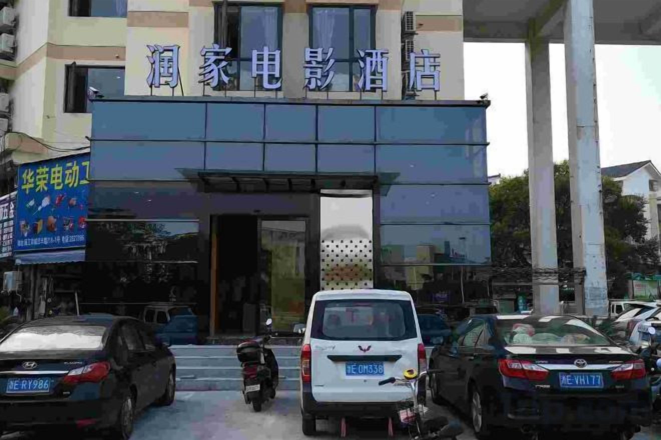 Un edificio con un letrero que dice 'Hotel Cinema Bar' y una motocicleta estacionada frente.