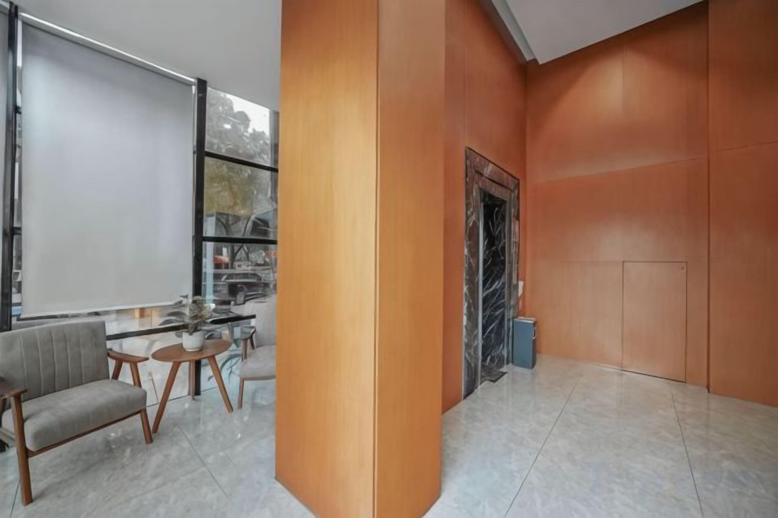 Un intérieur moderne avec un coin salon, une cheminée et une grande fenêtre.