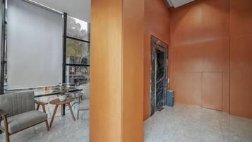 Un intérieur moderne avec un coin salon, une cheminée et une grande fenêtre.