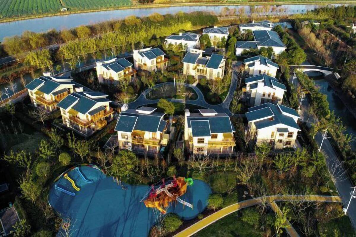 A residential area with houses, a swimming pool, and a bridge.