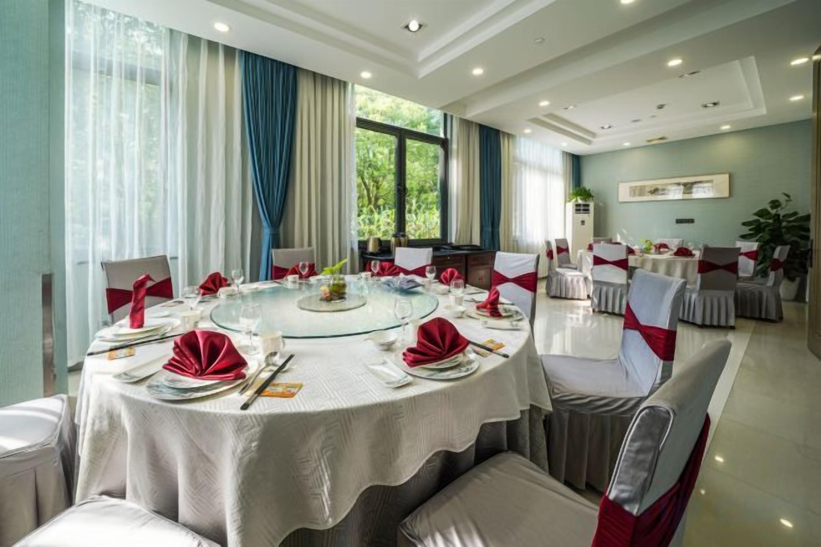A round table set for a formal event with chairs, a glass centerpiece, and table settings.