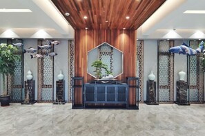 A lobby with a central console, decorative panels, and potted plants. - Yingdong Resort (Shanghai)