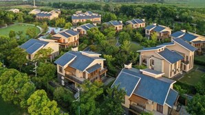 A residential area with multiple houses featuring sloped roofs, likely equipped with solar panels. - Yingdong Resort (Shanghai)