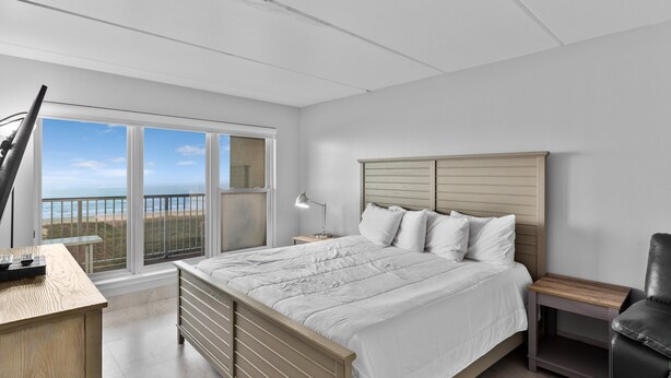 A bedroom with a bed, a desk, a chair, and a nightstand. - Breath-taking Ocean Views, Pool & Hot Tub. 5th Floor Beachfront Views! (South Padre Island)