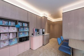 Ein Hotelzimmer mit einer Rezeption, einer Sitzecke mit Sesseln und einer Wand mit Stauraumschränken.