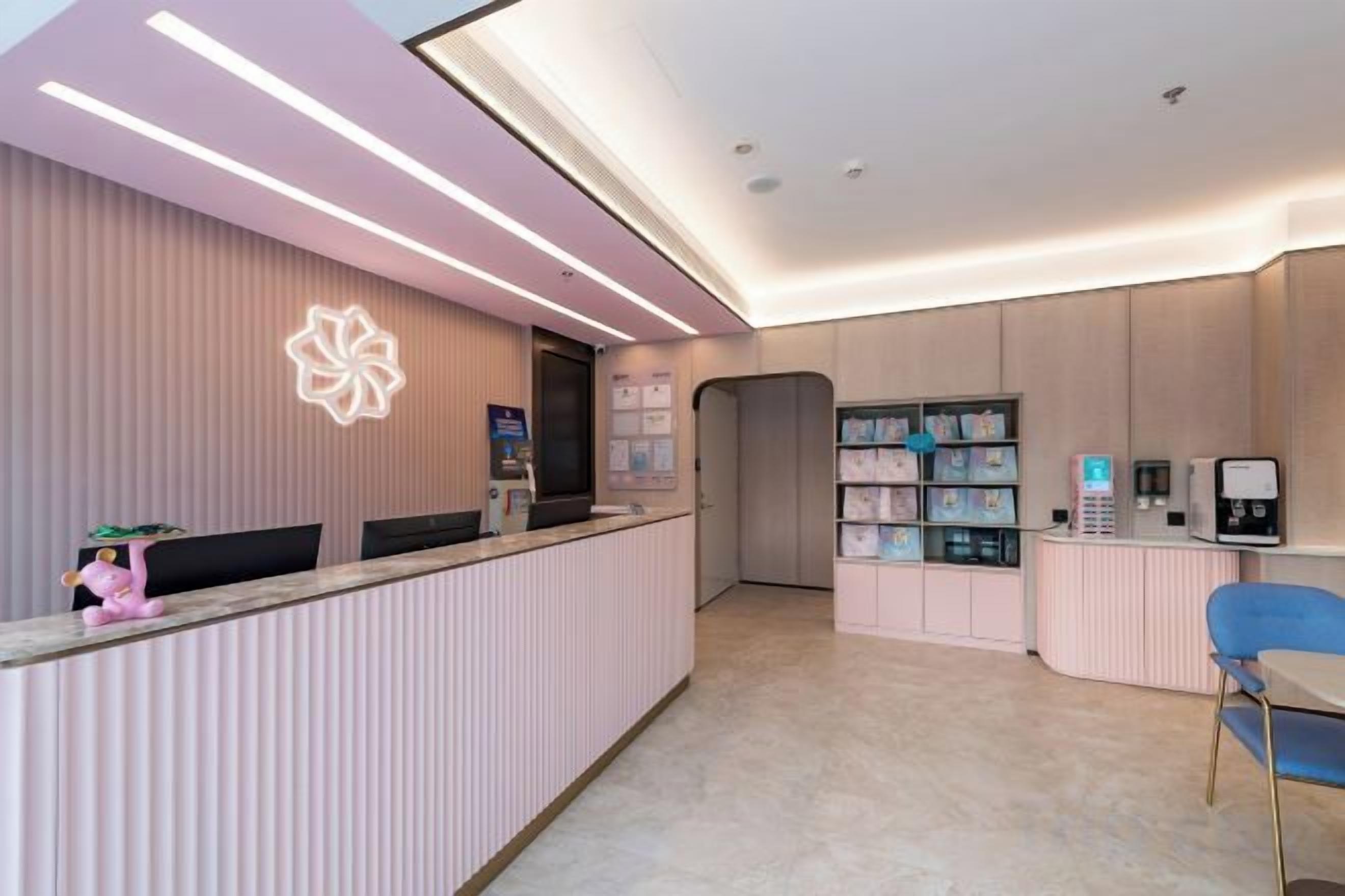A reception area with a counter, seating, and a wall-mounted information board.