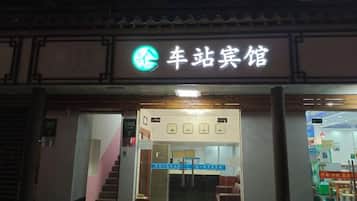 Entrada de hotel com uma placa que diz '车站宾馆' (Estação de Trem Hotel).