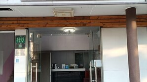 A modern hotel entrance with a glass door, a reception desk, and a sign indicating room number 2865. - chezhan hotel (Shanghai)
