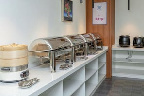 A buffet setup with multiple self-service stations, including a variety of food containers and utensils. - Golden Hotel (Sihui)