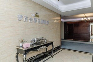 A reception area with a marble wall, a reception desk, and a sign indicating the 4th floor. - Golden Hotel (Sihui)