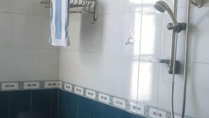 A bathroom with a shower, a towel rack, and a toilet. - Dongzhu Hostel (Shanghai)
