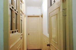 A narrow hallway with a door at the end, flanked by two doors on either side. - Dongzhu Hostel (Shanghai)