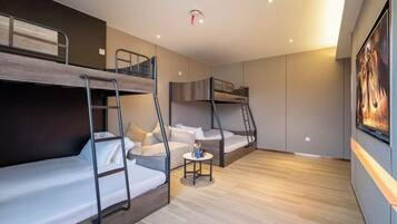 Una habitación de hotel moderna con literas, una mesita pequeña y un cuadro en la pared.