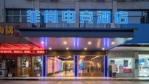A hotel entrance with a neon sign, air conditioning units, and a visible storefront. - Danyang Feshang E-sports Hotel (Danyang)