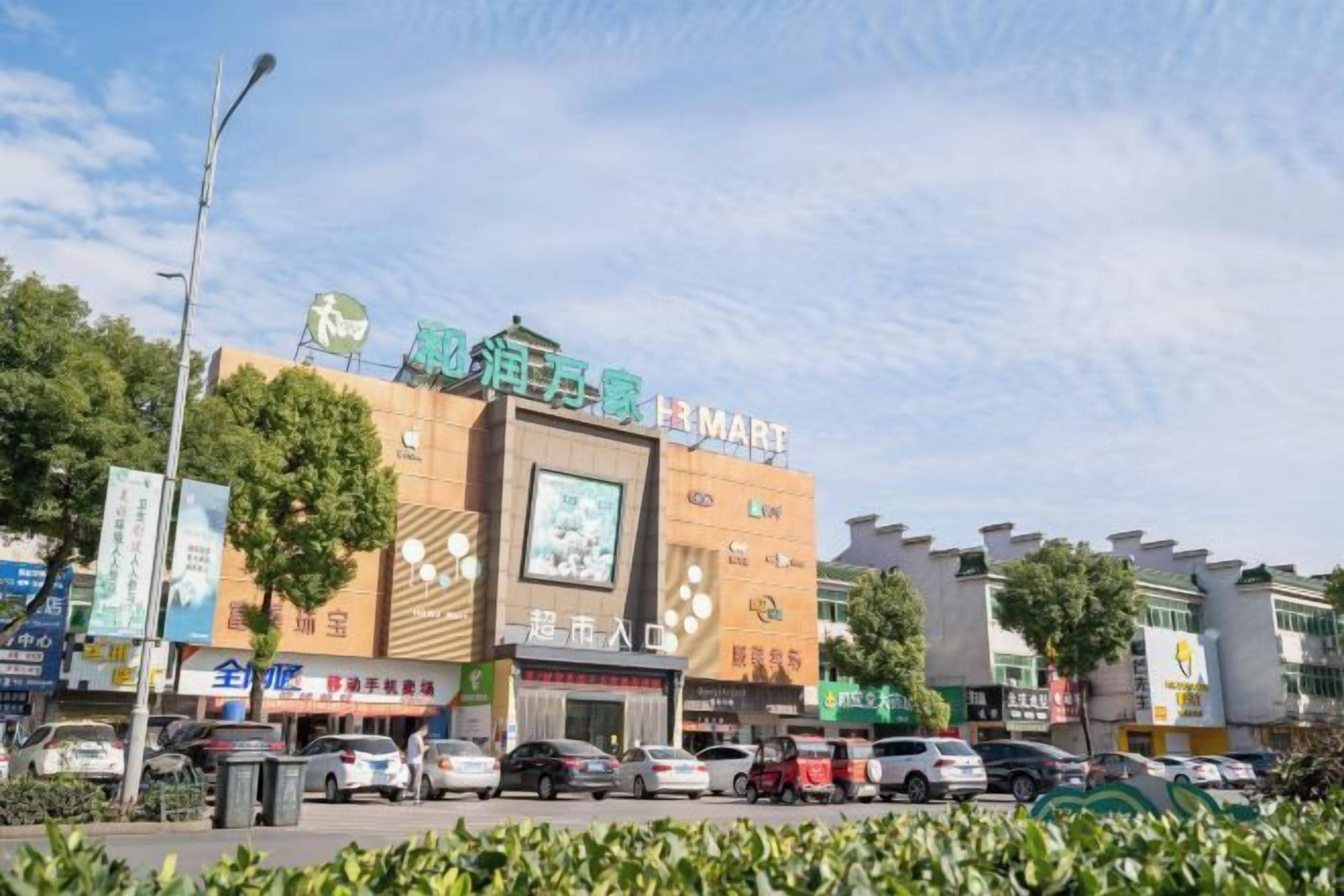 Un edificio comercial con varias tiendas, incluyendo un letrero visible de '3MART'.