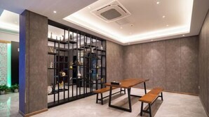 A modern room with a wooden table and benches, a decorative black shelving unit, and a recessed ceiling light. - Danyang Feshang E-sports Hotel (Danyang)